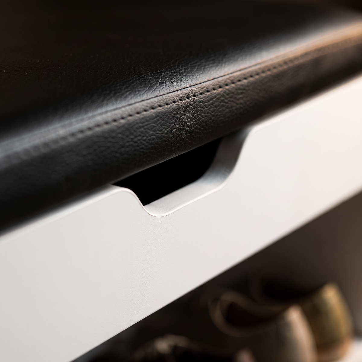 Close view of the stitched seam where the padded seat meets the cabinet