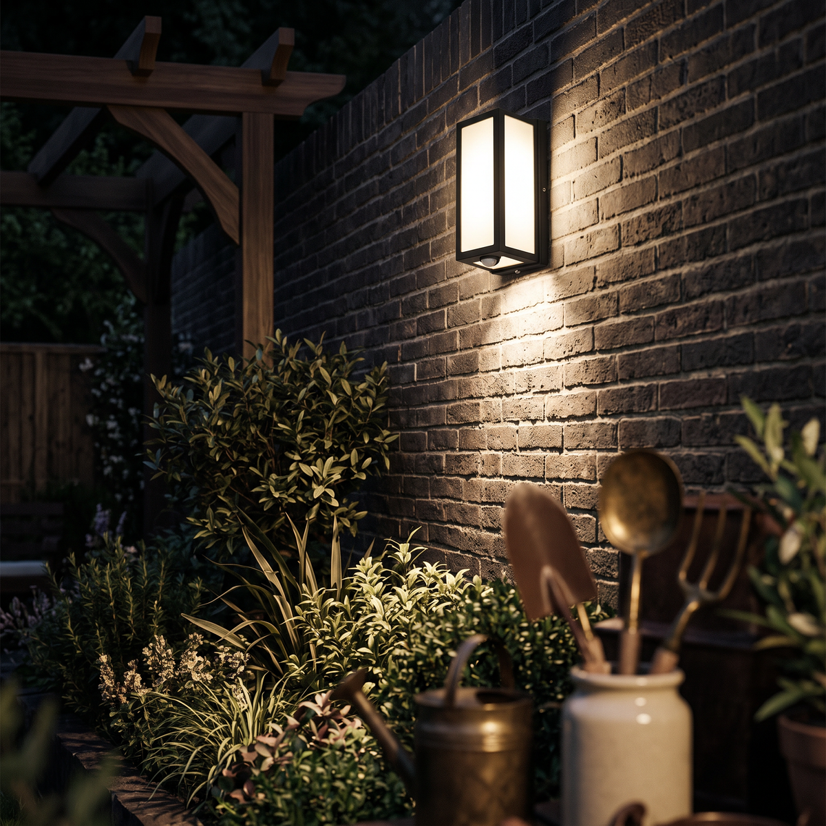 The light high on a brick boundary wall seen from the garden at night
